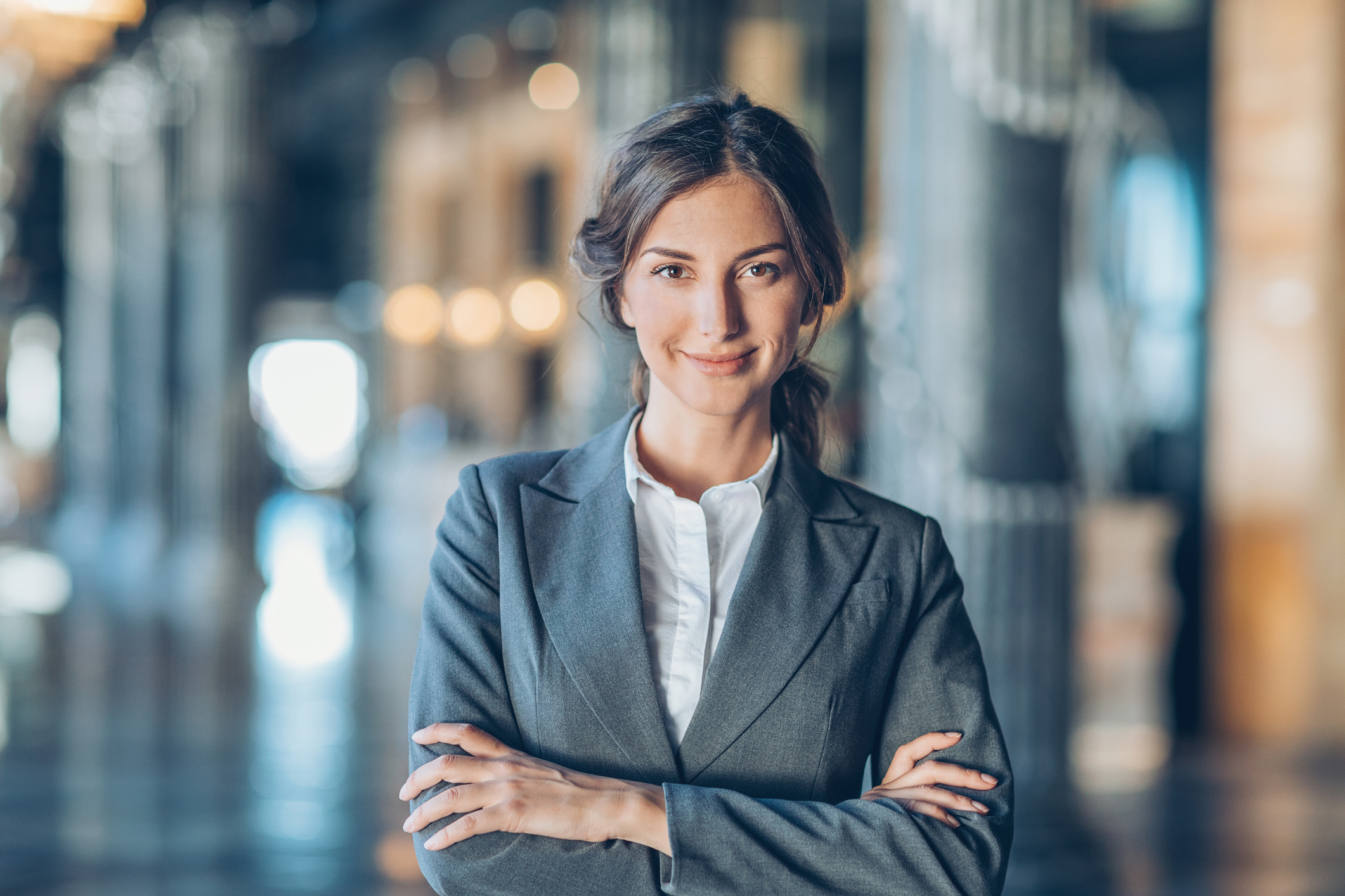 Businesswoman with arms crossed looking at camera, with copy space