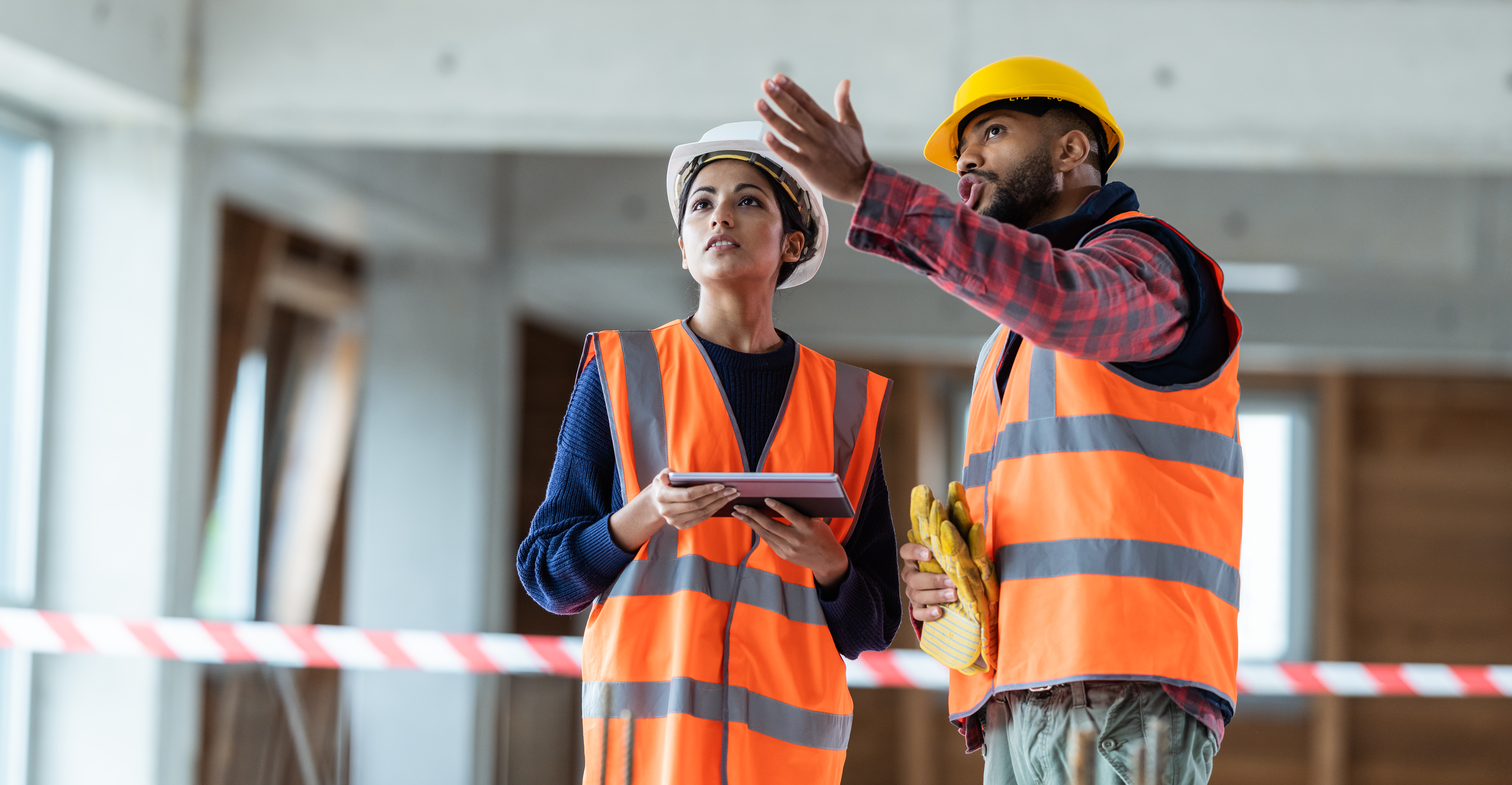 Female architect talking to construction site foreman using a digital tablet